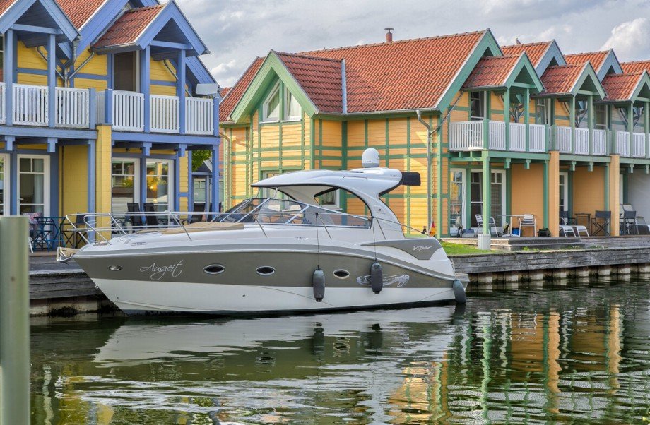 Ansicht des Eckhauses mit direktem Wasserzugang und privatem Bootsanleger Ferienhaus Rheinsberg